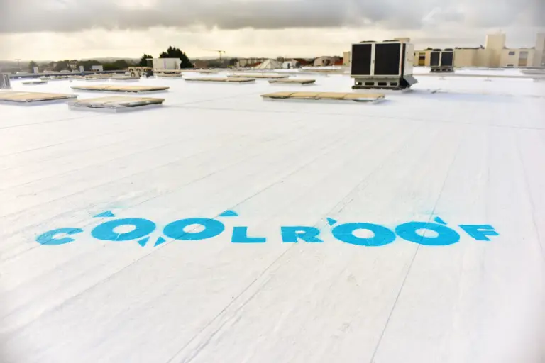 Logo Cool Roof peint en bleu sur un toit blanc